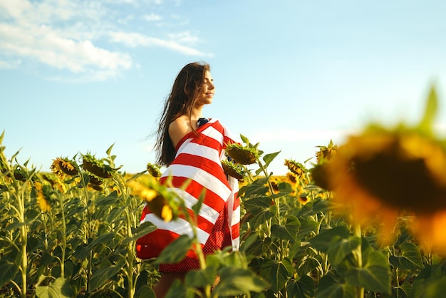 Belle fille au chapeau avec le drapeau américain dans un champ de tournesols 4 juillet 4 juillet Liberté