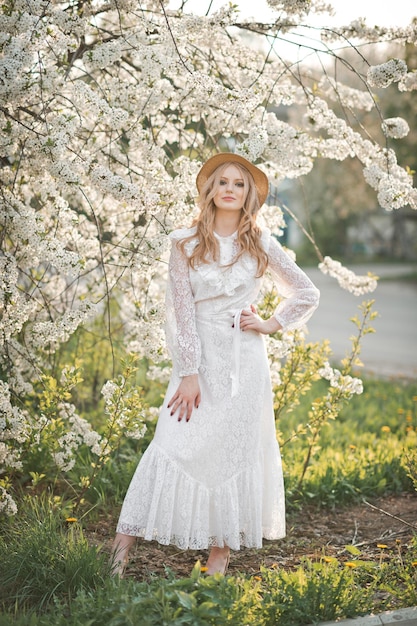 Une belle fille au chapeau parmi les arbres en fleurs 2722