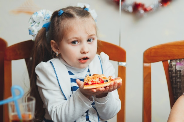 Belle fille au festival mangeant une tranche de pizza délicieuse