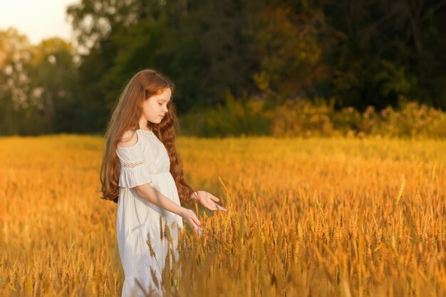 Belle fille aux cheveux bouclés sur champ de blé ou de seigle.