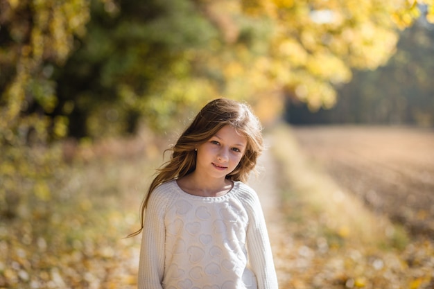 belle fille aux cheveux longs sur un chemin forestier