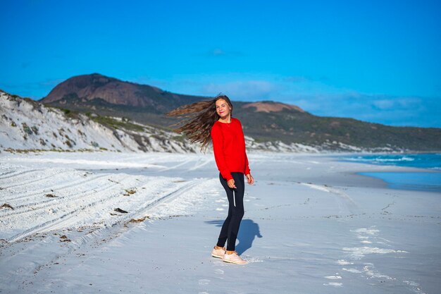 belle fille aux cheveux longs se promène au coucher du soleil sur la célèbre plage de lucky bay en australie occidentale