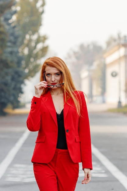 Belle fille aux cheveux rouges vêtue d'un costume rouge