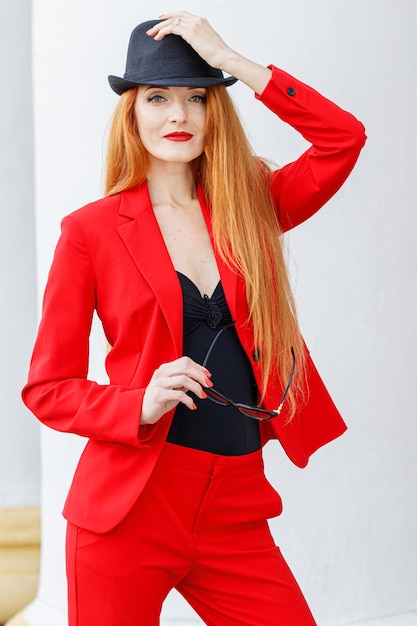 Belle fille aux cheveux rouges vêtue d'un costume rouge