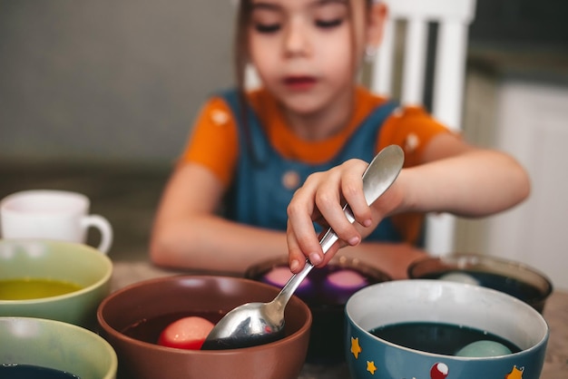 Photo belle fille aux oreilles de lapin peindre des oeufs de pâques