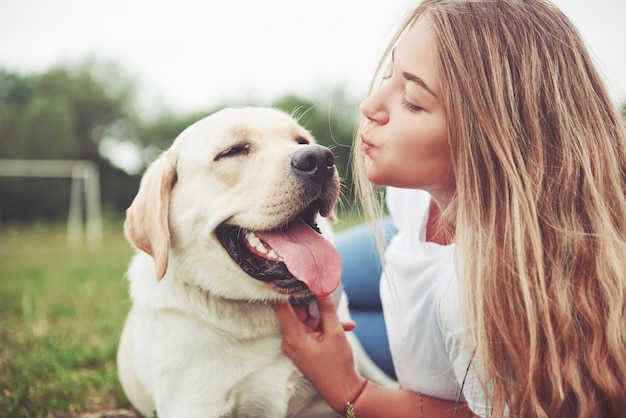 belle fille avec un beau chien dans un parc sur l'herbe verte.