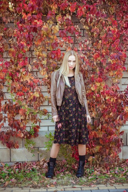 Belle fille blonde avec des feuilles d'automne portrait de raisin