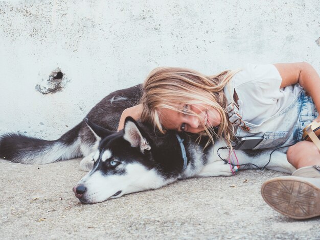 Belle fille blonde pose avec un animal Husky sibérien