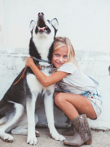 Belle fille blonde pose avec un animal Husky sibérien