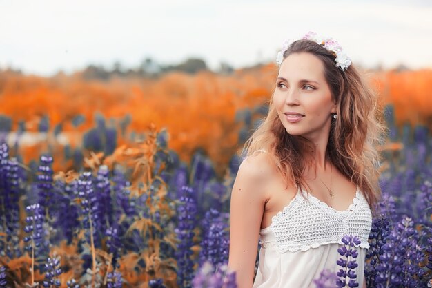 Belle fille avec un bouquet de fleurs bleues sur la nature en automne