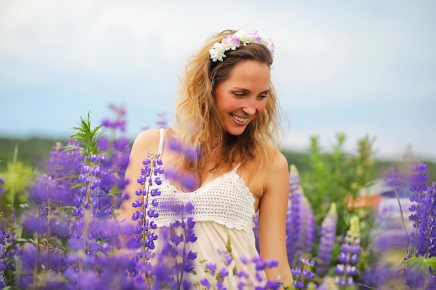 Belle fille avec un bouquet de fleurs bleues sur la nature en étéxA