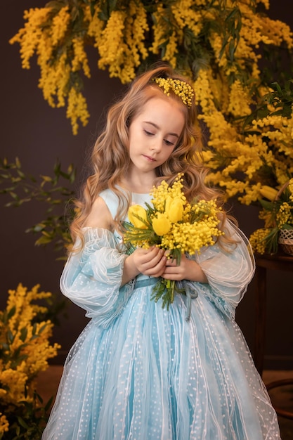 Belle fille avec un bouquet de fleurs de mimosa