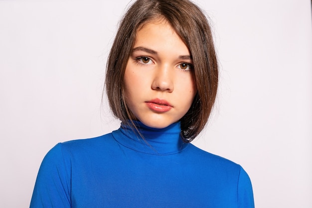 Belle fille branchée de hipster. Photo d'une belle jeune femme positive en chaussettes hautes bleues avec fond blanc. regarde la caméra. regarder la caméra