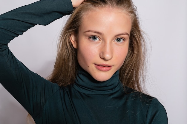 Belle fille branchée de hipster. Photo d'une jolie jeune femme positive dans des chaussettes hautes vertes avec un fond blanc. regarde la caméra.