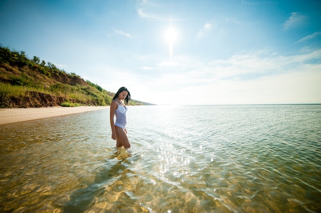 Belle fille bronzer et nager dans la mer