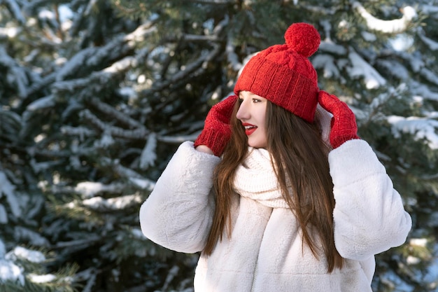 Belle fille brune au chapeau rouge et mitaines en plein air d'hiver Le petit chaperon rouge