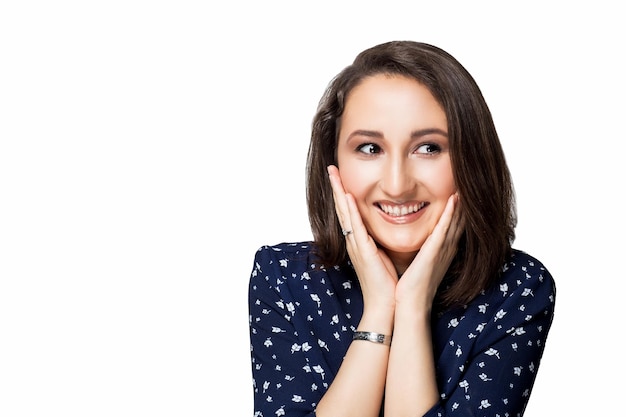 Belle Fille Brune Aux Cheveux Courts Dans Une Robe Bleue Mains Sur Les Joues Du Visage Avec Un Sourire En Regardant La Caméra Rire émotions Isoler Fond Blanc.