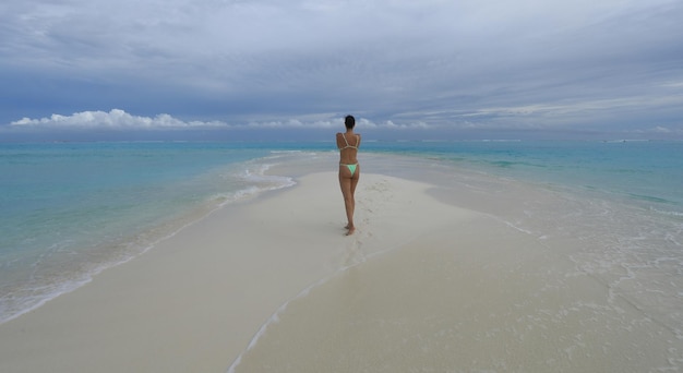 belle fille brune en bikini vert sur une île tropicale