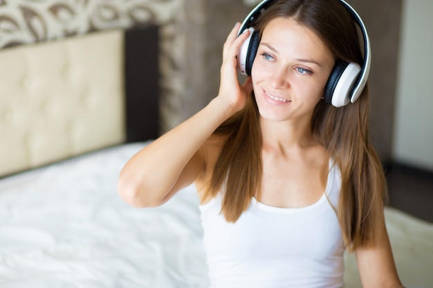 une belle fille brune avec un casque dans la chambre