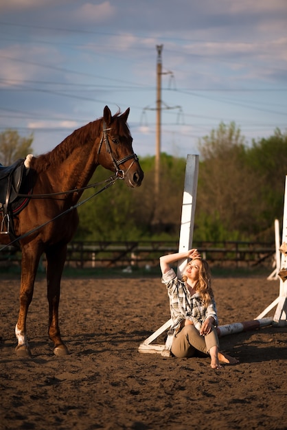 Belle fille brune avec son cheval à l'extérieur.