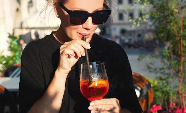 Belle fille buvant un cocktail dans un café