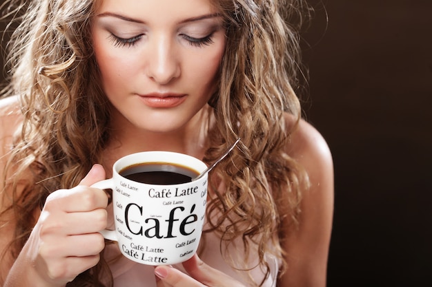 Belle fille buvant du thé ou du café.