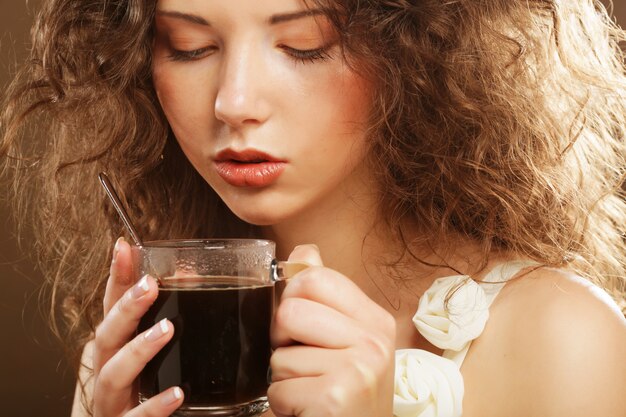 Belle fille buvant du thé ou du café.