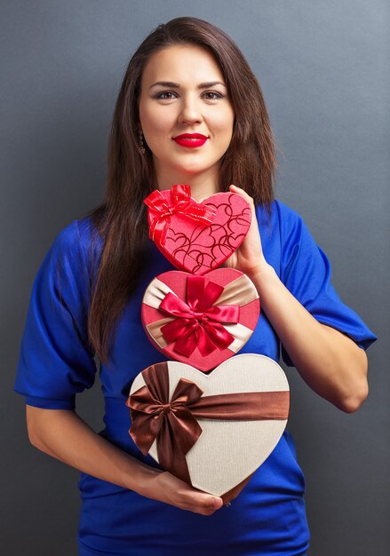 Belle fille avec des cadeaux sur fond gris