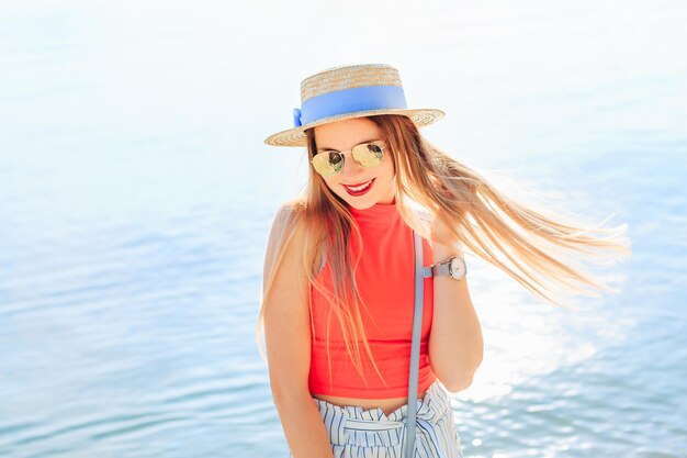 La belle fille en canotier de vêtements élégants et lunettes de soleil hol