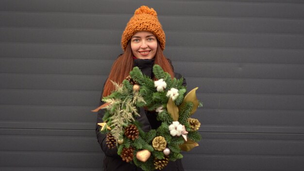 Belle fille caucasienne et guirlande de Noël à l'extérieur o na jour de neige