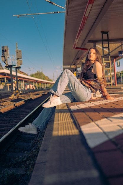 Belle fille caucasienne posant sur la plate-forme ferroviaire