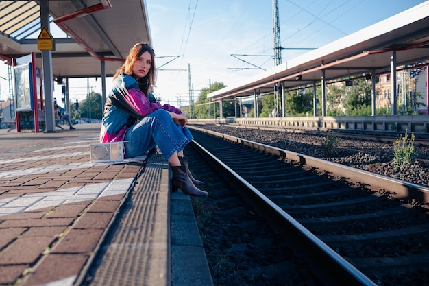 Photo belle fille caucasienne posant sur la plate-forme ferroviaire