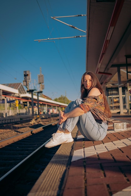 Belle fille caucasienne posant sur la plate-forme ferroviaire