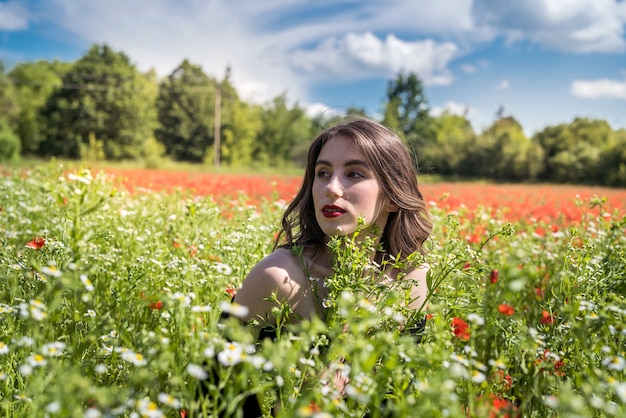 Belle fille sur le champ de fleurs, journée ensoleillée