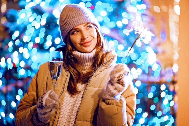 Belle fille avec une coupe de champagne et scintille