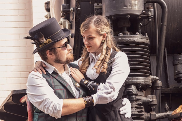 Belle fille avec un couple de gars amoureux dans des vêtements steampunk