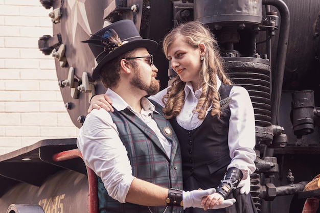 Belle fille avec un couple de gars amoureux dans des vêtements steampunk