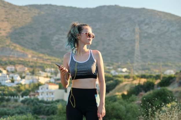 Belle fille de coureur de remise en forme à l'aide de smartphone et d'écouteurs