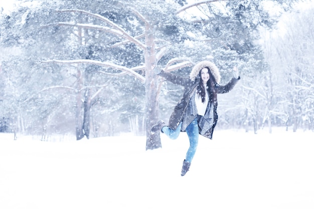 Belle fille dans un beau parc de neige d'hiver de jour