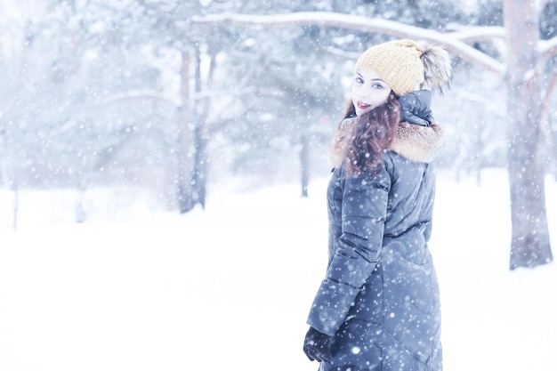 Belle fille dans un beau parc de neige d'hiver de jour