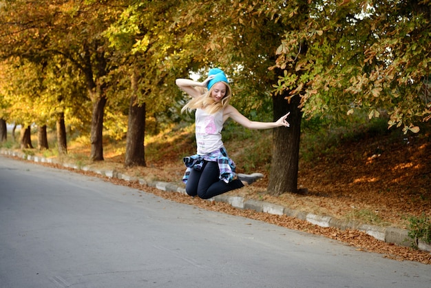 La belle fille dans un bonnet bleu sur la promenade