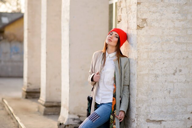 Belle fille dans un bonnet rouge se promène dans la ville