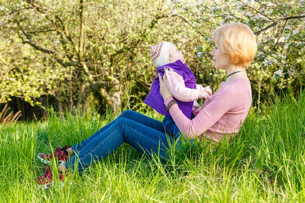 Belle fille dans les bras d'une enfant fille dans un parc fleuri