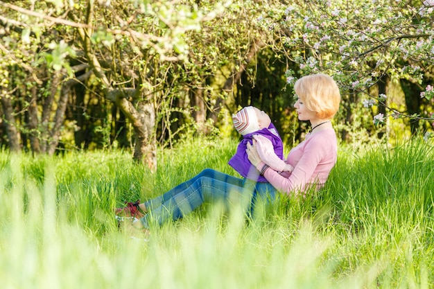 Belle fille dans les bras d'une enfant fille dans un parc fleuri