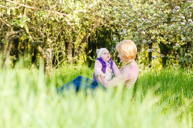 Belle fille dans les bras d'une enfant fille dans un parc fleuri