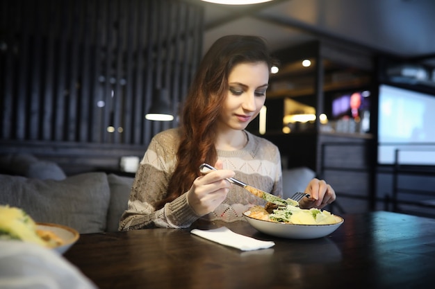 Belle fille dans un café prenant une tasse de café lors d'un dîner