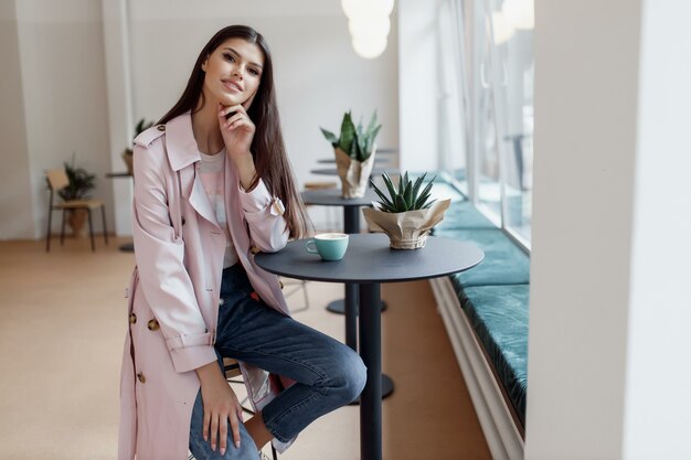 Belle fille dans un café avec une tasse de café