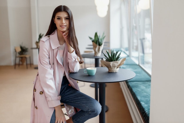 Belle fille dans un café avec une tasse de café