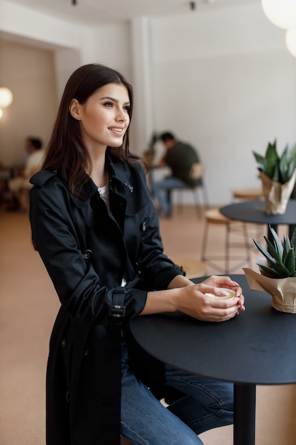 Belle fille dans un café avec une tasse de café