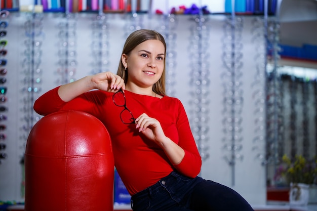 La belle fille dans un centre d'ophtalmologie prend des verres pour la correction de vision